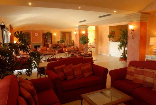 a living room with red couches and a dining room at Hotel Borgo Di Cortefreda - Place of Charme in Tavarnelle in Val di Pesa