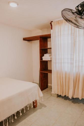 a bedroom with a bed and a window with a curtain at Departamento en Bahías de Huatulco in Santa Cruz Huatulco