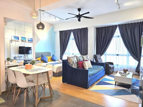 a living room with a blue couch and a table at Comfy Imperium Residence Kuantan Studio Seaview in Kuantan