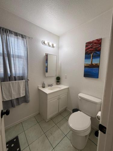 a bathroom with a white toilet and a sink at Flowers Apt 5 Min Walk to Downtown - Free Parking in Las Vegas