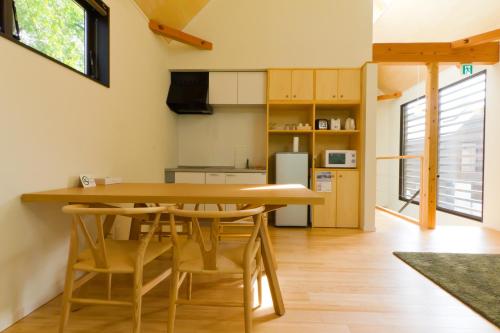 a kitchen and dining room with a wooden table and chairs at Gakuto Villas in Hakuba