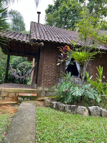 a small brick house with a window in a yard at Sitio Serenar Chalés Equipados in Penedo