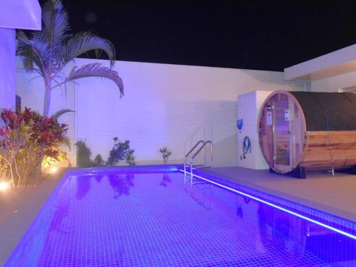 a large swimming pool with a barrel next to a building at The Pool & Sauna Villa MOTOBU in Motobu