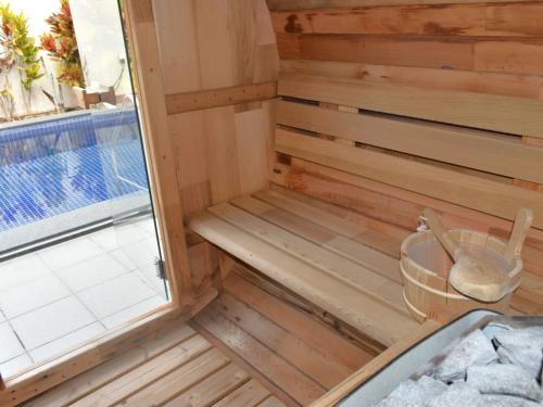 a wooden sauna with a window next to a swimming pool at The Pool & Sauna Villa MOTOBU in Motobu