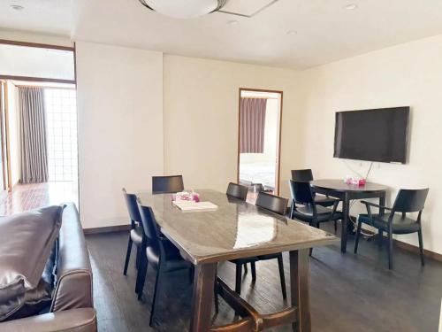 a living room with a table and chairs and a tv at 颯House 3-4 in Osaka
