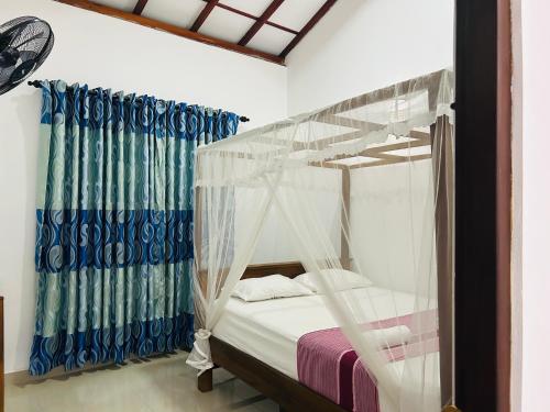 a bedroom with a bed with a canopy at Calm Palace in Weligama