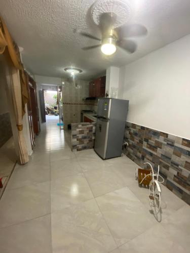 een keuken met een koelkast en een tegelvloer bij Hostal El Amanecer Costero in Santa Marta