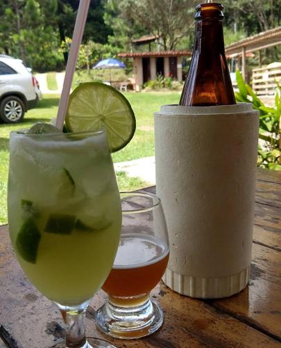 a table with two glasses and a bottle of beer at Aconchego Caminho das Cachoeiras in Rio Acima