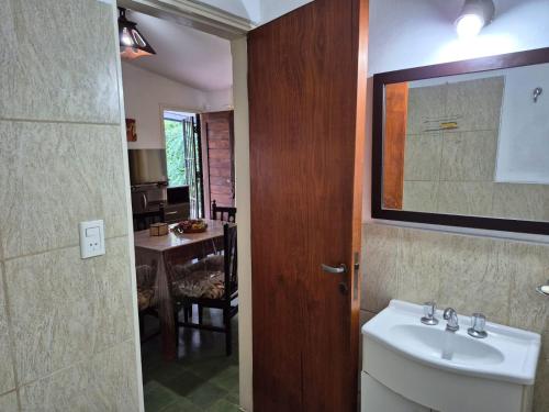 Un baño con lavabo, espejo y mesa. en Don EDELMI 2, en Córdoba