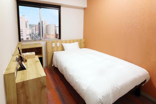 Postel nebo postele na pokoji v ubytování Sasebo Green Hotel