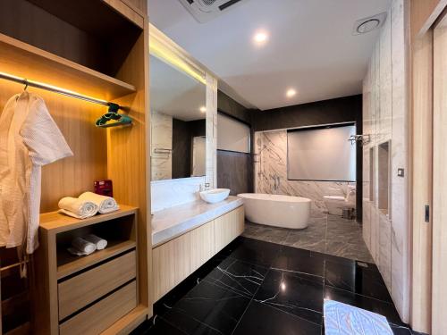 a bathroom with a tub and a toilet and a sink at Celine House by Craft Village in Chaweng