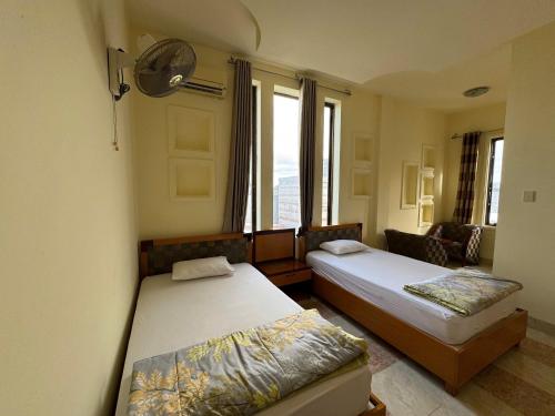 a bedroom with two beds and a window at Ho Phong Hotel in Phan Rang