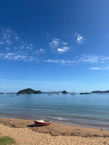 a boat sitting on the sand on a beach at Peppertree Lodge in Paihia