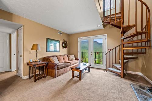 a living room with a couch and a spiral staircase at Rocky Top Oasis in Gatlinburg