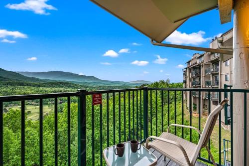 a balcony with a chair and a table and a view at Rocky Top Oasis in Gatlinburg