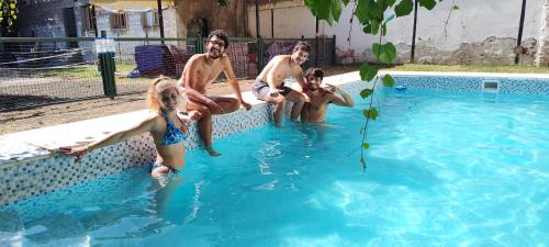 a group of people sitting in a swimming pool at Clover Hostel in Mendoza