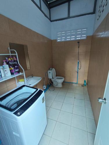 a bathroom with a washing machine and a toilet at Chiangmai Love U Villas in Chiang Mai