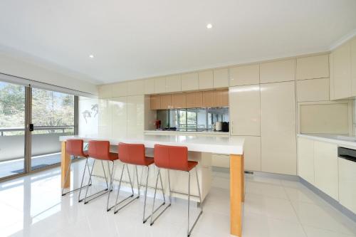 eine Küche mit weißer Arbeitsplatte und roten Stühlen in der Unterkunft Spacious 2-Bed Apartment Near Dining & Attractions in Kingston 