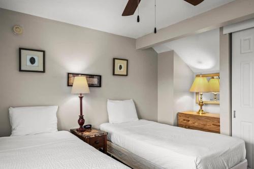 2 camas en un dormitorio con paredes blancas en Tennessee Ridge, en Gatlinburg