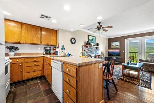 een keuken met houten kasten en een woonkamer bij Pinewood Escape in Gatlinburg