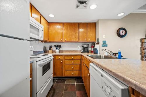 een keuken met houten kasten en een witte koelkast bij Pinewood Escape in Gatlinburg
