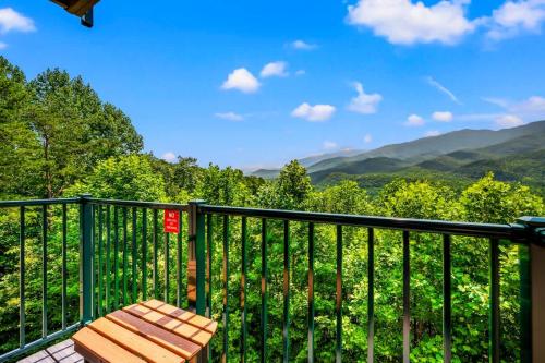 a wooden bench sitting on a balcony with a view of mountains at Point of View in Gatlinburg