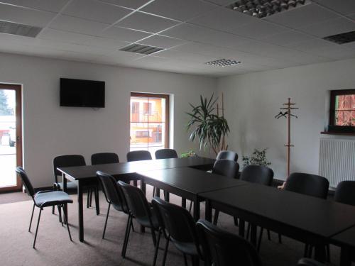a conference room with tables and chairs and a television at Penzion u Petra in Jeseník