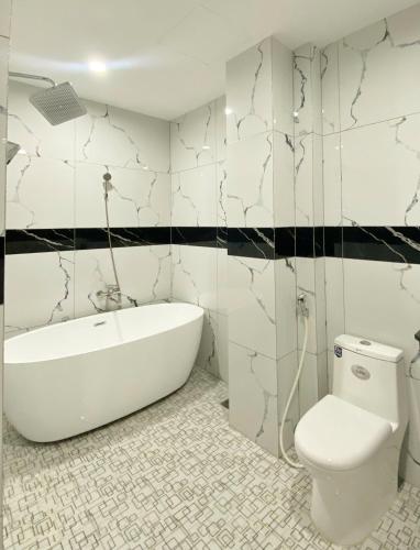 a bathroom with a white tub and a toilet at Thanh Binh Premium Hotel in Ho Chi Minh City