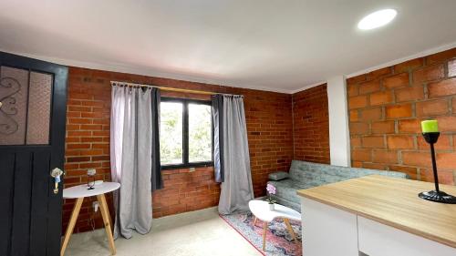 a living room with a brick wall and a window at Apartamentos cerca a canchas Panamericanas Barrio Olimpico - Luxury Apartments in Cali