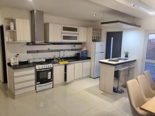 Una cocina con gabinetes blancos y un horno de estufa. en Residencial Las Heras, en Las Heras