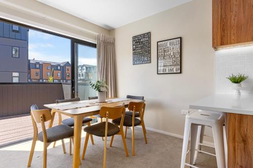 uma sala de jantar com mesa e cadeiras e uma janela em New 4BRs Townhouse, Walk to Shops & Cafes, 5mins to Airport, 30mins to Ski em Queenstown