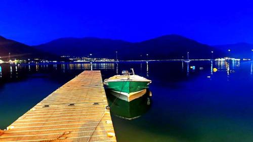 a boat sitting on the water next to a dock at Luz del Mar in Kumbor