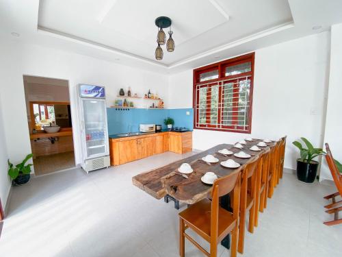 a dining room with a large wooden table and chairs at Nhà Bống Villa in Hoi An