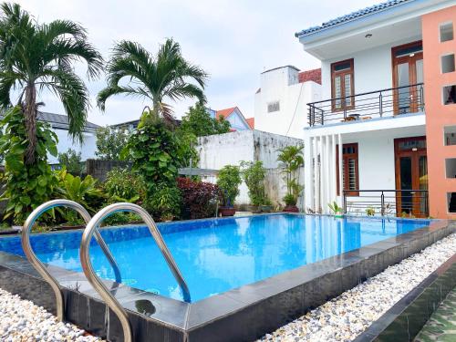 a swimming pool in front of a house at Nhà Bống Villa in Hoi An