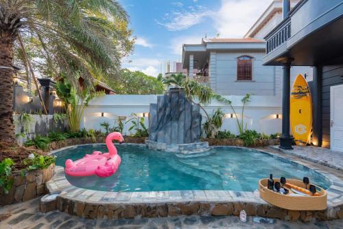 a pool with a pink flamingo in the water at Villa Candle In The Wind - Gần Bãi Sau Vũng Tàu in Vung Tau