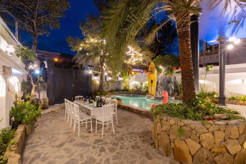 a patio with a table and chairs next to a pool at Villa Candle In The Wind - Gần Bãi Sau Vũng Tàu in Vung Tau