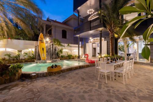 a house with a swimming pool and a table and chairs at Villa Candle In The Wind - Gần Bãi Sau Vũng Tàu in Vung Tau