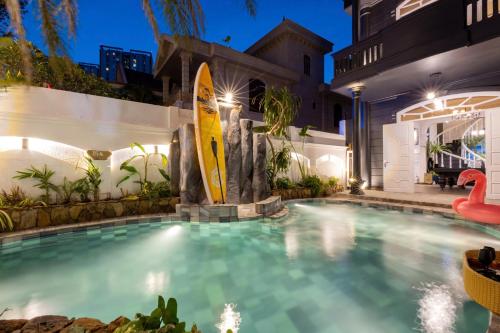 a swimming pool with a surfboard in a house at Villa Candle In The Wind - Gần Bãi Sau Vũng Tàu in Vung Tau