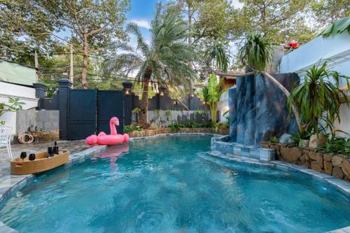a pool with a pink flamingo in a backyard at Villa Candle In The Wind - Gần Bãi Sau Vũng Tàu in Vung Tau