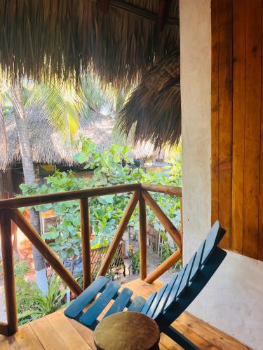 a balcony with two blue chairs and a table at Blue House in Puerto Escondido