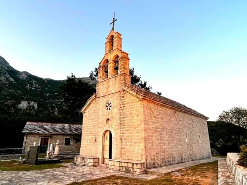 an old brick church with a cross on top of it at Luz del Mar in Kumbor