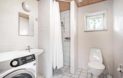 a white bathroom with a toilet and a sink at Nice Home In Nørre Nebel With Sauna in Nørre Nebel