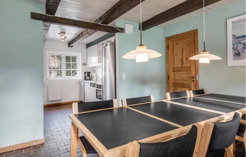 a dining room with a black table and chairs at Gorgeous Home In Ulfborg With Sauna in Ulfborg