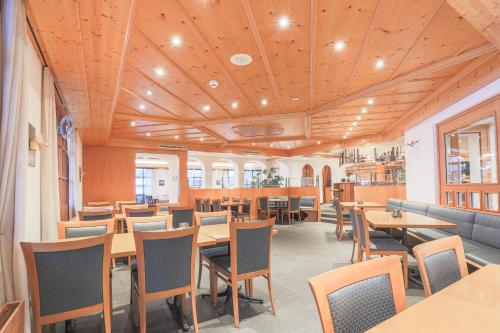 a restaurant with wooden ceilings and tables and chairs at Hotel Alpin Superior in Saas-Fee
