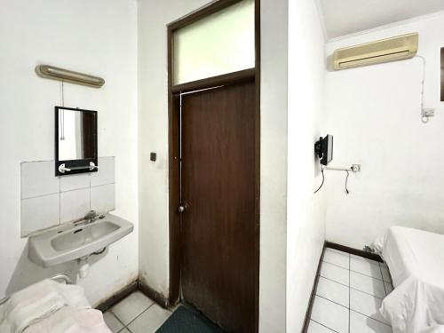 TimuranHotel Dewi Sri Prawirotaman RedPartner的一间带门和水槽的浴室