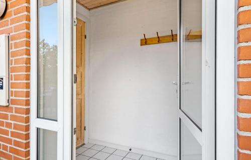 a glass shower door in a room with a brick wall at Nice Home In Nørre Nebel With Sauna in Nørre Nebel