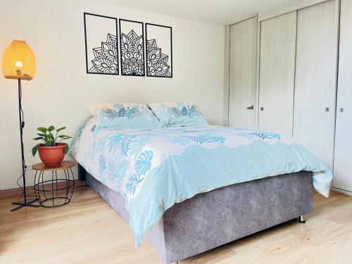 a bedroom with a bed with a blue comforter at Comfy loft in La Candelaria in Bogotá