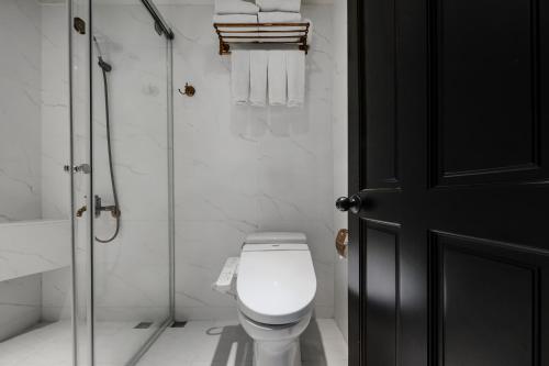 a white bathroom with a toilet and a shower at Dream Mansion Hotel in Taichung