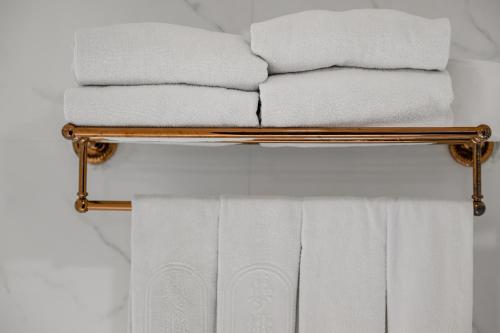 a pile of towels on a towel rack in a bathroom at Dream Mansion Hotel in Taichung