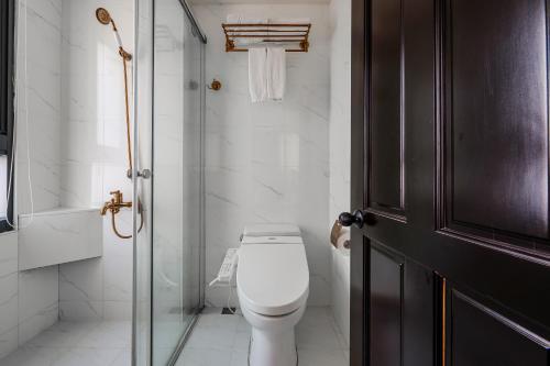 a bathroom with a toilet and a glass door at Dream Mansion Hotel in Taichung